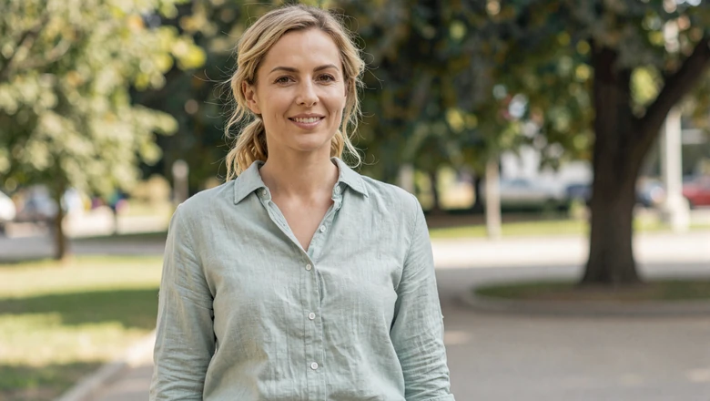 Woman smiling naturally in a sunny park setting showing what an authentic dating profile photo looks like